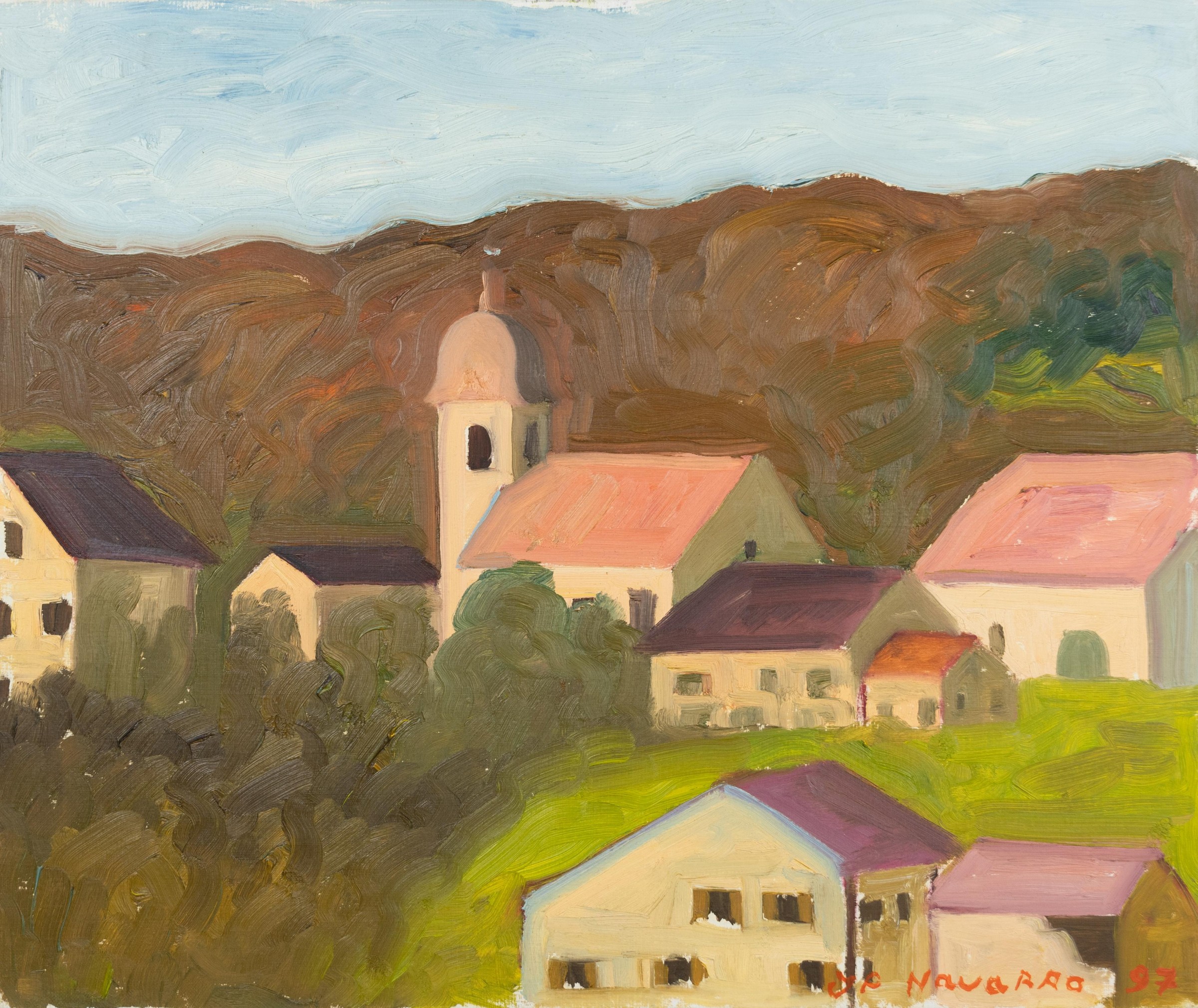 Maisons d’un village en pente avec un clocher d’église devant une colline sous un ciel bleu clair