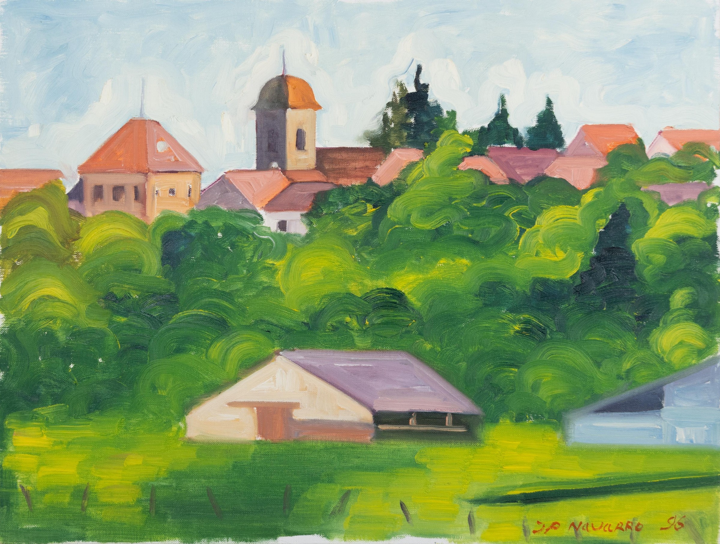 Village aux toits rosés avec un clocher d’église derrière une végétation dense sous un ciel bleu clair