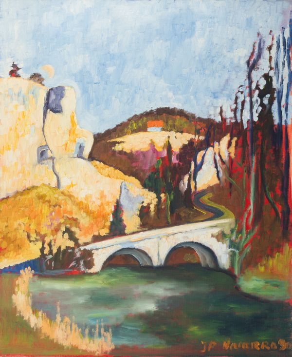 Pont en pierre à deux arches sur une rivière au pied d’une falaise claire sous un ciel bleu