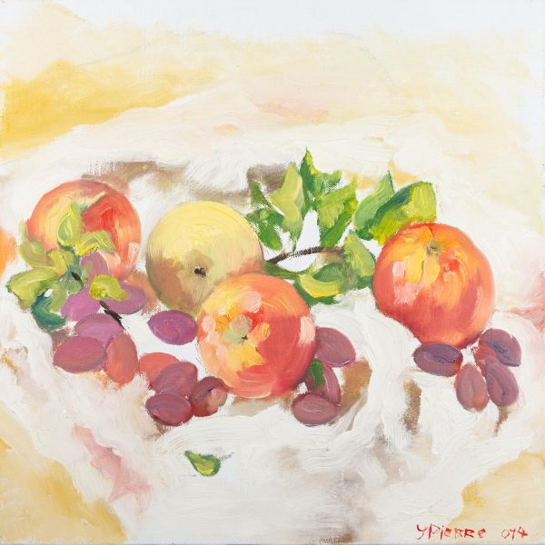 Quatre pommes et des prunes disposées sur une table avec des feuilles vertes.