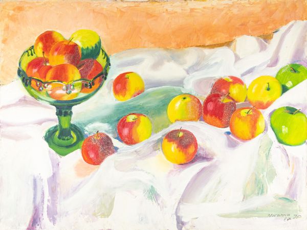 Bol de pommes colorées sur une nappe blanche avec des pommes éparses.