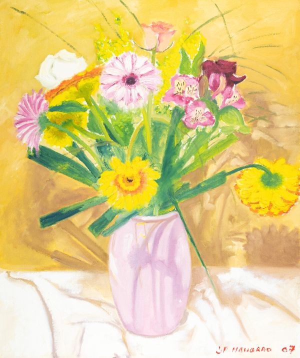 Bouquet de fleurs colorées dans un vase sur une nappe blanche.